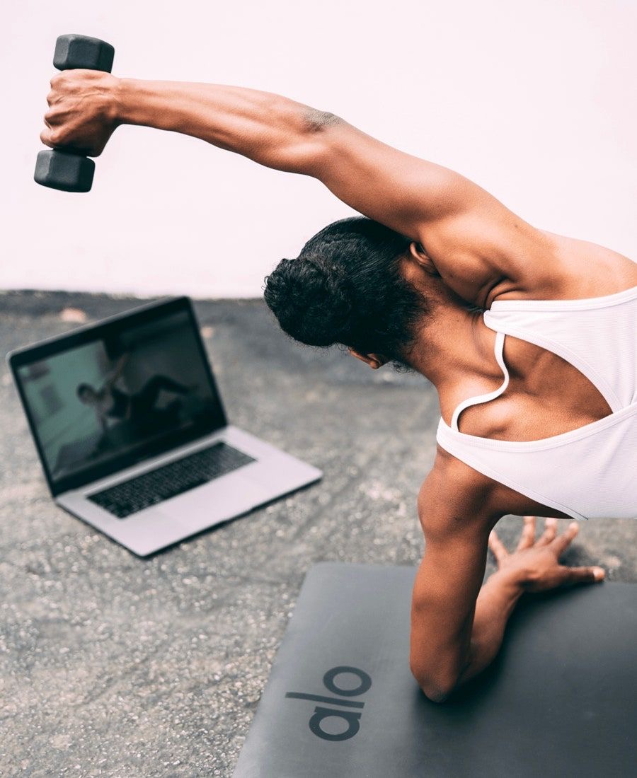 female working out at home with online trainer